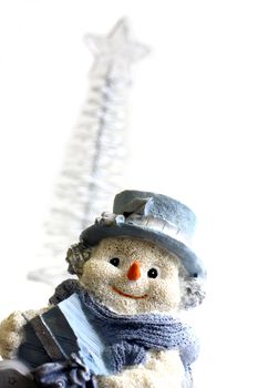 Shot of Snowman figurine with a christmas tree in the background