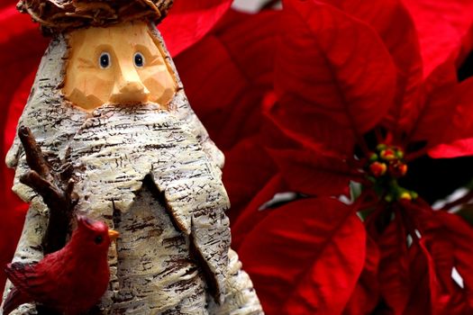 Wooden Statue of Santa Claus with Poinsettia backdrop