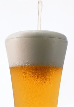 Light beer poured in a glass isolated on a white background