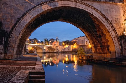 Bridge crossing the river Tiber and Cathedral in twilight