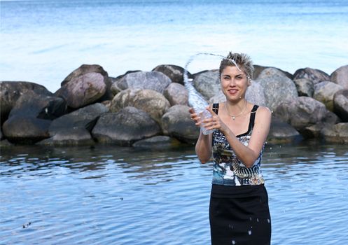 Cute blond girl playing with water in the summer in Denmark
