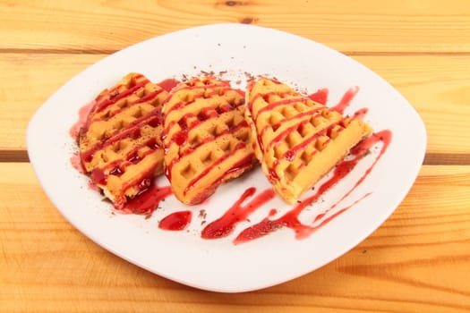 Waffles with strawberry on wooden table