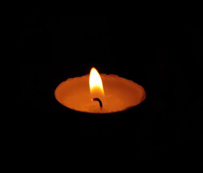 A single burning yellow candle