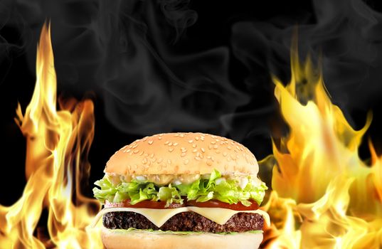 Hamburger with fire on black background