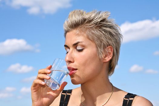 Cute blond girl playing with water in the summer in Denmark