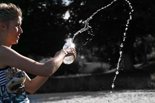 Cute blond girl playing with water in the summer in Denmark