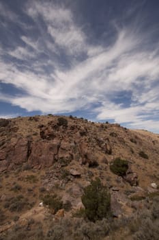 High deset rocky hillside with blue sky and beautiful couds