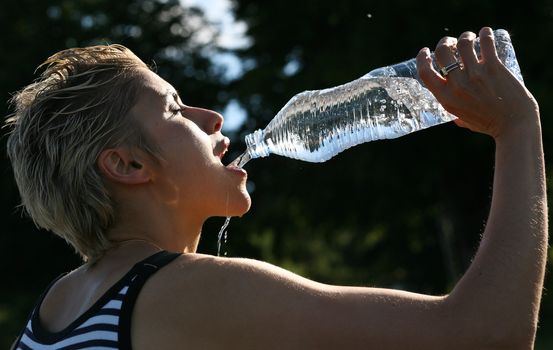 Cute blond girl playing with water in the summer in Denmark