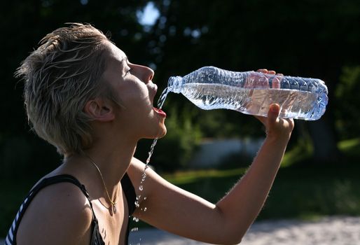 Cute blond girl playing with water in the summer in Denmark