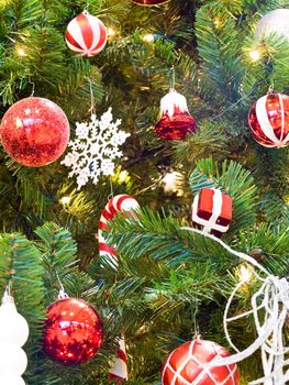 Red and White Christmas Ornaments on a Green Tree with White Lights