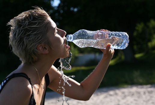 Cute blond girl playing with water in the summer in Denmark