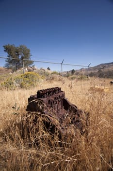 Old rusty engine block abandoned in the field.