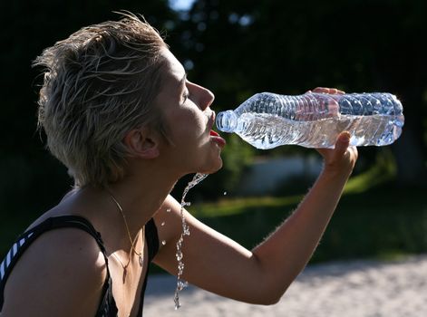 Cute blond girl playing with water in the summer in Denmark