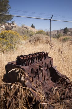 Old rusty engine block abandoned in the field.