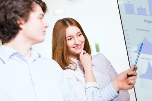 attractive business woman with a colleague discussing charts and graphs on the screen, Collaboration