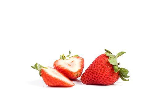 Fresh ripe red strawberries on white. The strawbery in front is sliced in half.