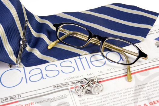 Jobs classified market on newspaper with ties tieclip cufflinks and glasses