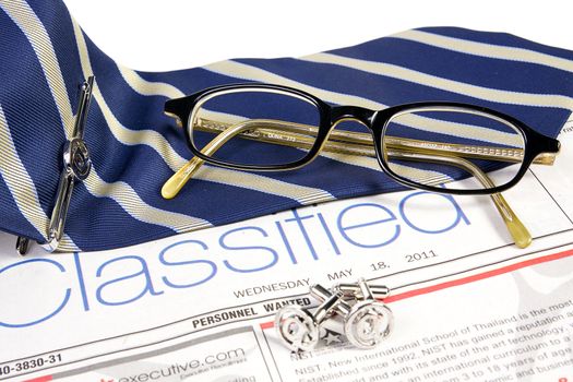 Jobs classified market on newspaper with ties tieclip cufflinks and glasses