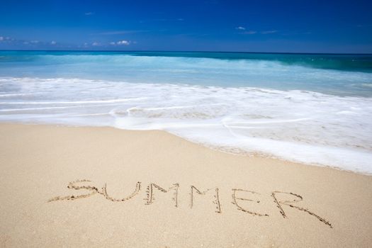 Beautiful tropical beach with the word summer written on the sand