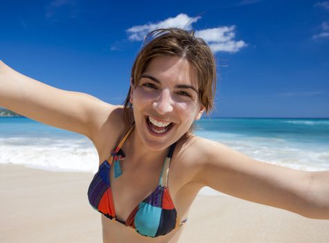 Beautiful and happy young woman  enjoying the summer on a tropical beach 