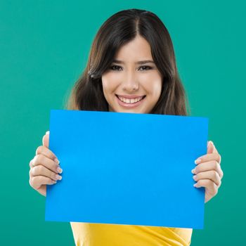 Beautiful asian woman holding a blue billboard, over a green background
