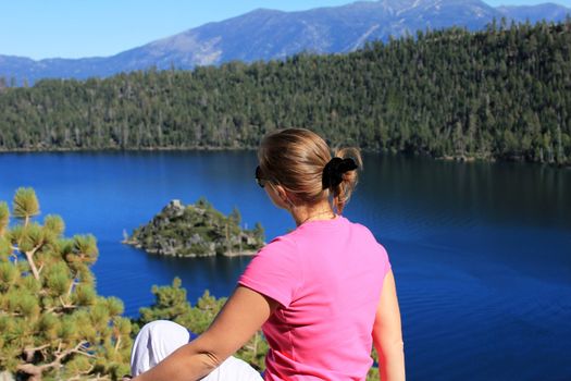 The girl sits on a coast of Lake Tahoe