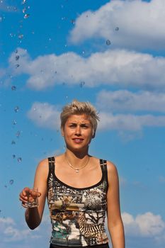 Cute blond girl playing with water in the summer in Denmark