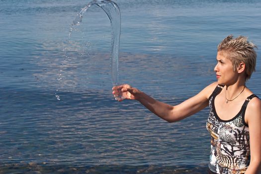 Cute blond girl playing with water in the summer in Denmark