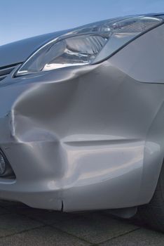 A dent in the right front quarter of a european car