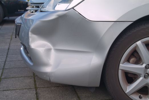 A dent in the right front quarter of a european car