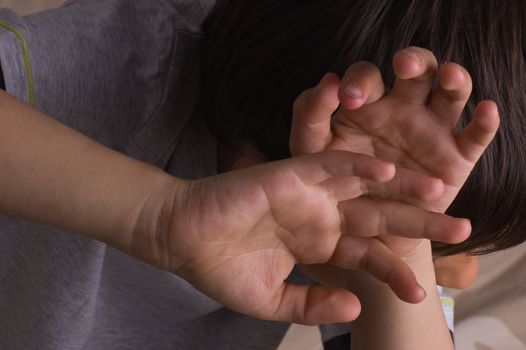 Child raising hands to protect itself