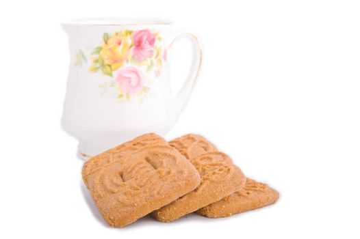 Speculaas dutch cookie stacked in front of bone china tea cup on white