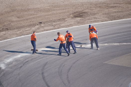 ZANDVOORT, THE NETHERLANDS - OCTOBER 10:  Race officials cleaning the track surface after an incident at Formido Finale Races at Circuit Park Zandvoort in Zandvoort, The Netherlands on October 10, 2010