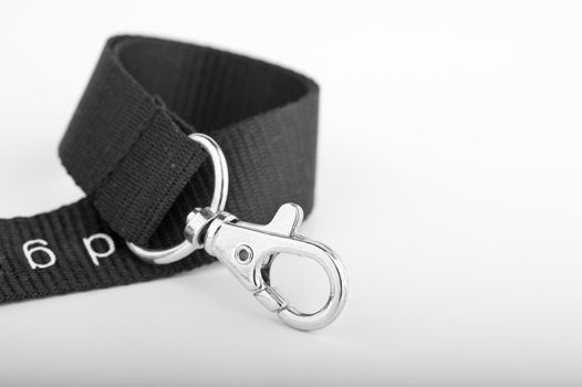 Chrome Key ring clip on curled up black lanyard on gradient background