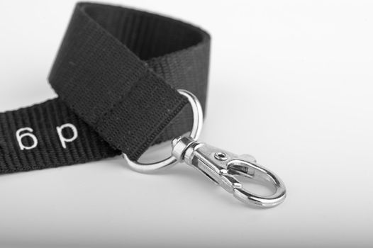 Chrome Key ring clip on curled up black lanyard on gradient background