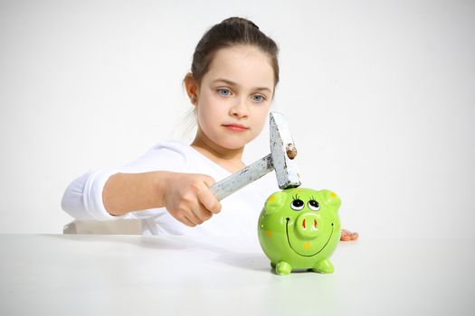 Little girl breaking piggy bank isolated on white