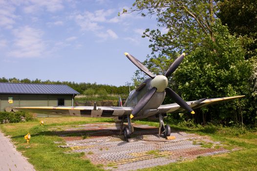 Tied down British Supermarine Spifire in front of shack