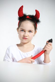 Little girl dressed as pretty imp in studio