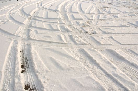 Car tire track in fresh light snow