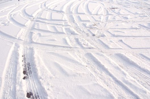 Car tire track in fresh light snow