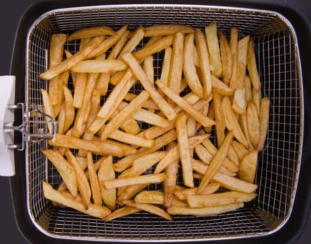 Freshley baked french fries in an electric frying pan basket