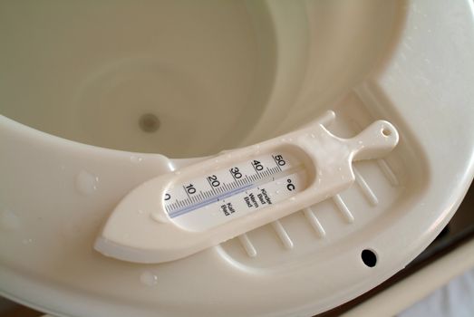 Thermometer on the rim of a baby bath tub