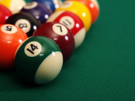 Macro photo of a pool table and billiard balls with space for copy. Shallow depth of field with focus on the fourteen ball.