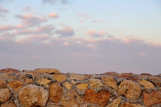 landscape, a stone wall and the sunset sky for background