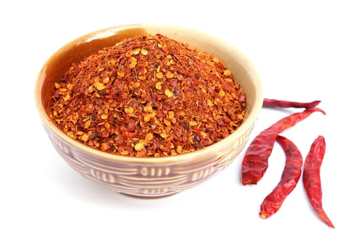 Crushed dry red pepper in a bowl on white background 