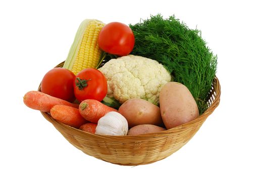 Harvested vegetables mix including  corn, potatoes, garlic, tomatoes, dill  and cauliflower in straw bowl isolated on white background