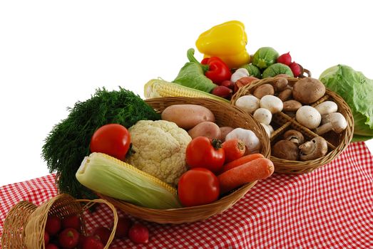Farmer market stand with rich vegetables selection including  carrot, tomatoes, potatoes, onion, corn, lettuce, cauliflower, dill, sweet pepper  and mushrooms on red-white tablecloth