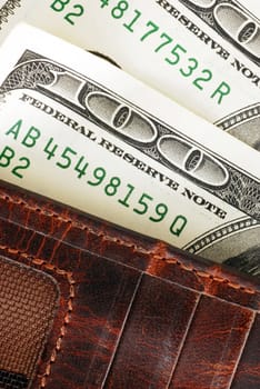 Two banknotes of hundred dollars in brown wallet closeup macro