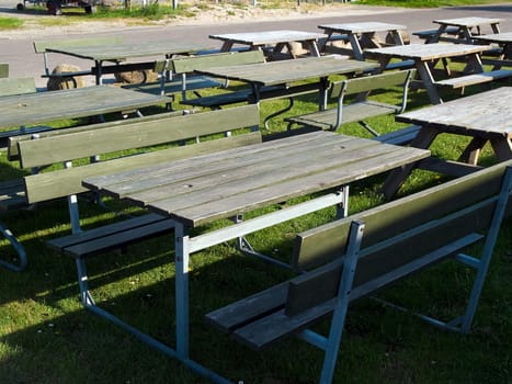 Wooden picnic tables arranged outdoors in nature
