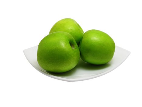 Three green apples on square dish isolated on white